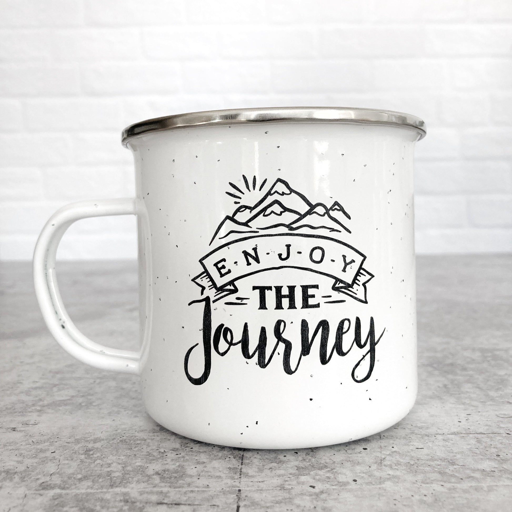 Enjoy the journey design on a white enamel mug