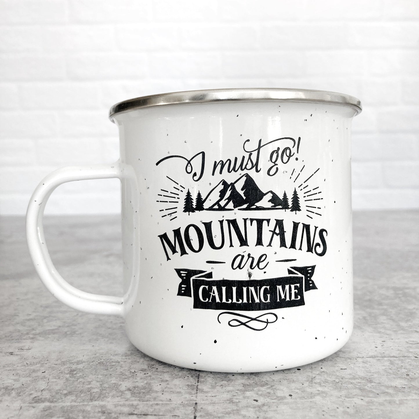 I Must Go! Mountains Are Calling Me design on a white enamel mug